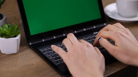 Close up of female hands typing and green laptop on the table. Stock Footage 107799794