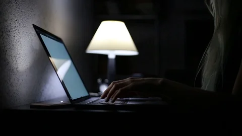 Close-up of female hands typing on keyboard of laptop, in dark room. Stock Footage 115737005
