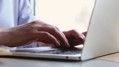 Close up of female hands typing on modern laptop keyboard making notes writing Stock Footage 229348140