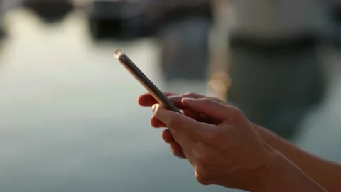 Close-up of female hands typing text on the touch screen of the phone 動画素材 159737605