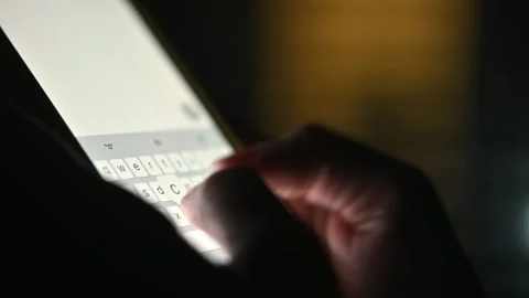 Close-up of female hands typing text on the phone at night. Chatting, Internet Stockbeeldmateriaal 217688017