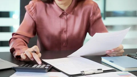 Close-up of female hands using calculator for financial calculations at desk  스톡 동영상 332850571