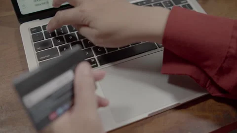 Close-up of female hands using a credit card for online payment on a laptop 库存影片 334517900