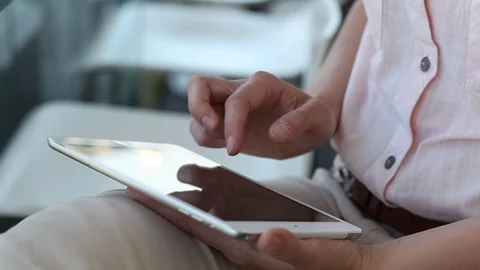 Close up of female hands using digital tablet computer on her knees Stock Footage 98099649