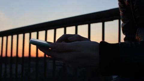 Close up female hands using mobile phone at balcony terrace on sunlight sunset Stock-Footage 74955866