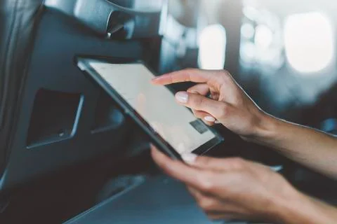 Close-up of female hands using modern digital tablet at airplane Stock Photos