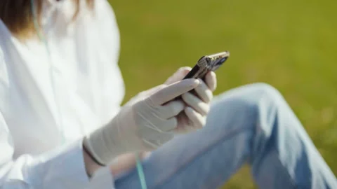 Close up of female hands using phone in a city park. 動画素材 130244483