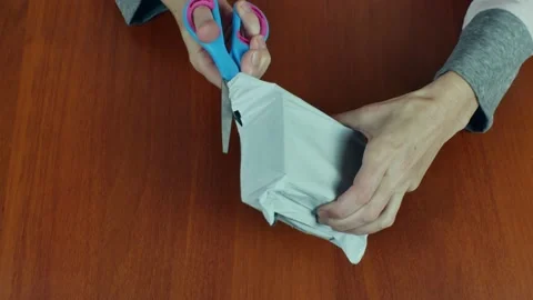 Close-up female hands using scissors cut a plastic bag and take out a parcel in Stock Footage 220695777