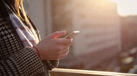 Close up of female hands using smartphone on the balcony of her apartment Stock Footage 61838346