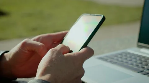 Close-up of female hands using smartphone outdoors with sun glare on screen Stock Footage 313126782