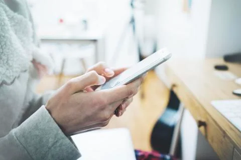 Close-up of female hands using smartphone at home Stock Photos