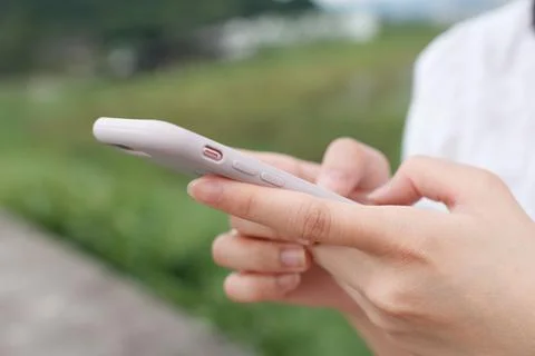 Close up of female hand's using the smartphone at the outdoor. Stock Photos