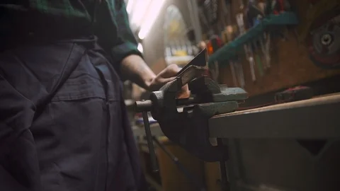 Close up female hands using a vice to secure the metal bar Видео 105237149