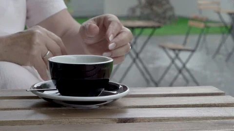 Close-up of female hands while drinking tea. It is raining heavily Stock Footage 92634874