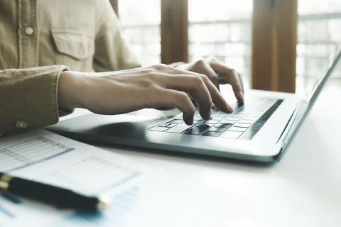 Close up of female hands while typing on laptop. Stock Photos