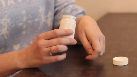 Close-up of female hands with white plastic jar of medicine Stock Footage 327802375