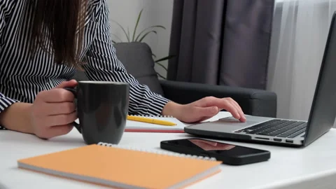 Close up of female hands working computer typing on keyboard and hold cup coffee Stock Footage 213861017