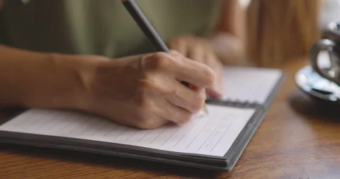 Close up of female hands writing to do list on blank notepad.Woman making Stock Footage 158958168