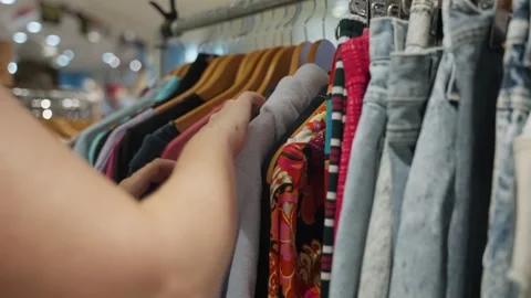 Close up on female hangs looking for clothes in second hand vintage thrift store Stock Footage 319538410
