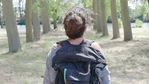 Close-up of a female hiker from the back with a backpack observing the forest Stock Footage 138097026