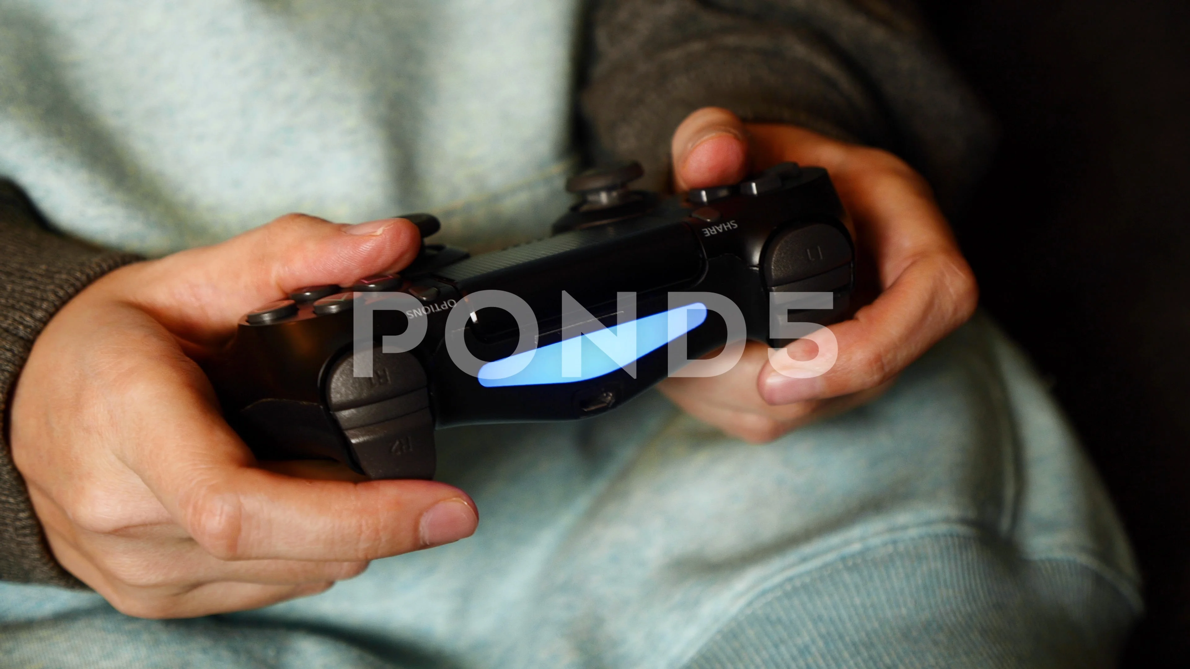 Close up of gamer holding controller and playing video games on computer.  Woman using joystick to play online digital games in front of monitor.  Person with modern gaming equipment Stock Photo 