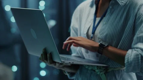 Close-up female IT worker using laptop for maintenance in web server cabinet Stock Footage 121224392