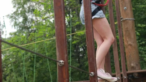 Close-up of female legs overcoming obstacles in a rope park. Outdoor recreation Stock Footage 281221953