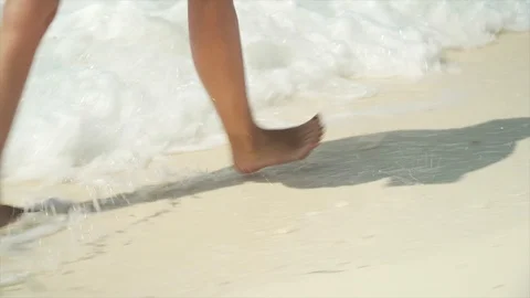 Close up of female legs walking on sandy beach Stock Footage 104902384