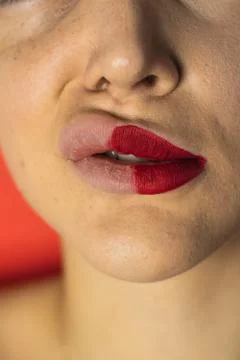 Close up of female lips with two different lipsticks. Red background Stock Photos