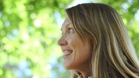 Close-up of female in a mackintosh looking at the camera and smiling Stock Footage 77201267