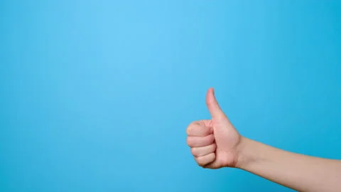 Close up of female makes thumb up gesture, demonstrates approval or agreement Stock Footage 133107972