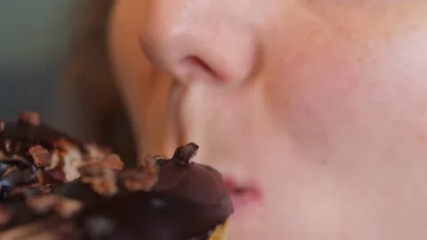 Close up of a female mouth eating vegan doughnut with chocolate icing Stock Footage 157411703