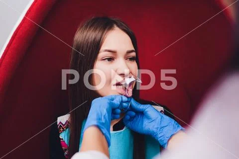 Close up of female mouth with retractor. Doctor flossing the teeth. Dental Gag. Stock Photos