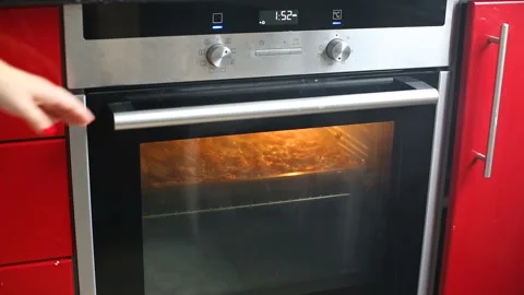 Close up of female opening oven at kitchen and grilling pizza or casserole. Stock Footage
