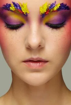 Close-up female portrait with eyes closed and unusual face art make-up and fr Stock Photos