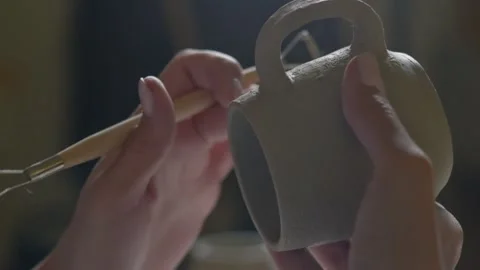 Close up of female potter using tool to finishing to making ceramic clay cup in Video stock 143617741