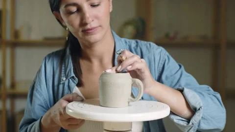 Close up of female potter using tools to making ceramic clay cup in potter Stock-Footage 143617599