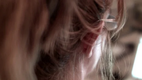 Close-Up of a female reading with glasses, back of head profile shot Stock Footage 72776322