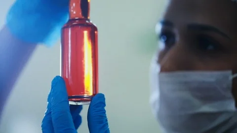 Close up of a female scientist inspecting a bottle of purified macauba Stock Footage 101714192