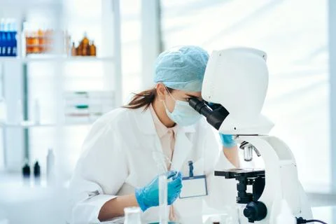 Close up. female scientist looking through a microscope. Stock Photos