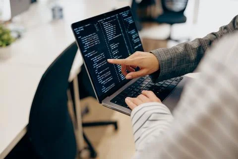 Close up of female software engineer showing something on laptop with screens 写真素材