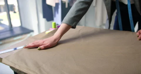 Close up of female tailor hands smoothing fabric on the table at cozy atelier Stock-Footage 155386028