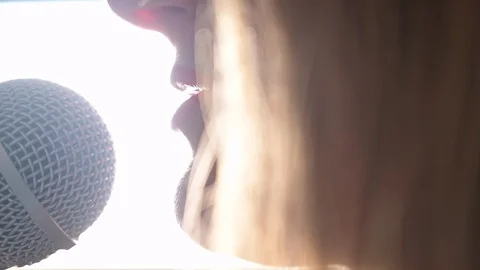 Close up of  Female Talking Singer Singing Into A Microphone Backlight Video stock 128709049