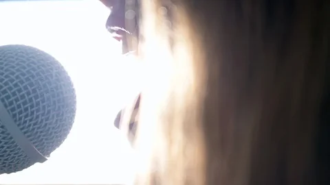 Close up of  Female Talking Singer Singing Into A Microphone Backlight 스톡 동영상 128709187