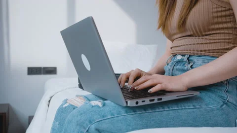 Close up female using laptop sitting on the bed in a hotel room Stock-Footage 163375250