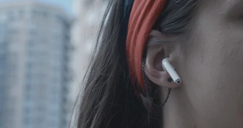 Close up female using wireless earphones outdoor. Switching music with headphone Stockbeeldmateriaal 126831333