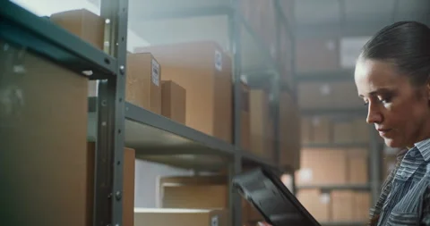 Close Up of Female Warehouse Associate Scanning Parcel with Online Order Using Stock Footage 307715451