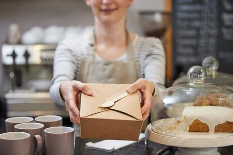 Close Up Of Female Worker in Cafe Serving Meal In Sustainable Recyclable Pack Stock Photos