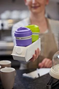 Close Up Of Female Worker in Cafe Serving Coffee Or Hot Drink  In Sustainab.. Foto stock