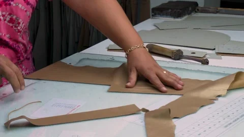 Close-Up of Female Worker Hands Cutting Leather Pieces for Jacket Production Stock Footage 322057528